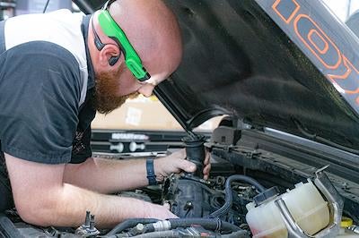Karl CDJR of Marshalltown technician performing an oil change